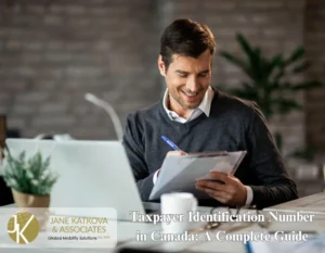 Application form for a Canadian Taxpayer Identification Number on a desk with a pen.
