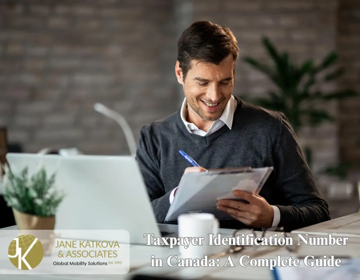 Application form for a Canadian Taxpayer Identification Number on a desk with a pen.